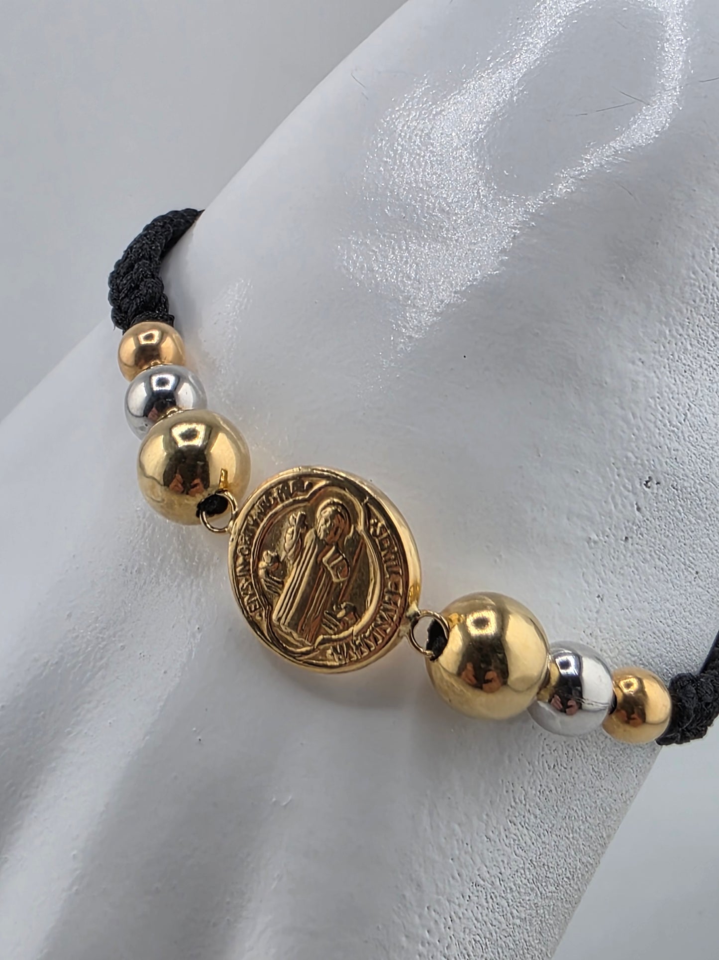 Black bracelet with 3 gold spheres and Saint Benedict charm
